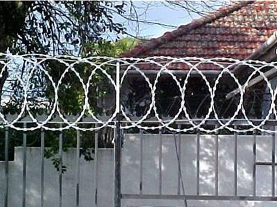 Installation of razor wire flat wrap coils is particularly simple when it is fitted by overlapping the fence mesh