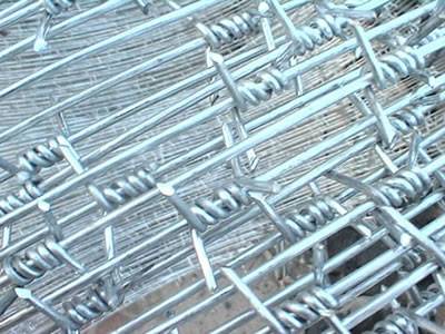A roll of galvanized single twist barbed wire and a detail of single strand and twist.