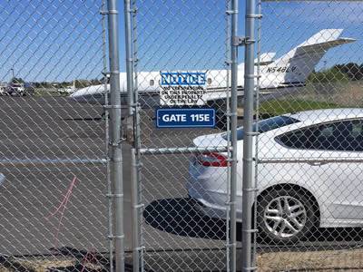 A galvanized airport security fence with a small gate is placed at airport.