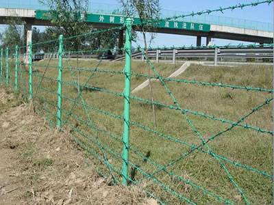 PVC coated barbed wires are installed on the posts outside of the highway.
