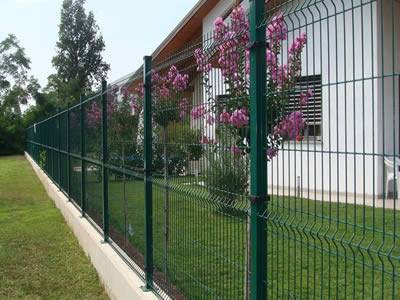 A dark green PVC coated welded 3D security fence with 3 curves is installed as a security wall for building fencing.