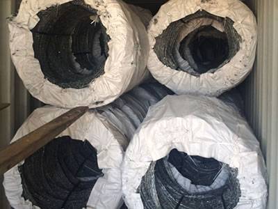 Several rolls of concertina barbed wire in the container with woven bag package.