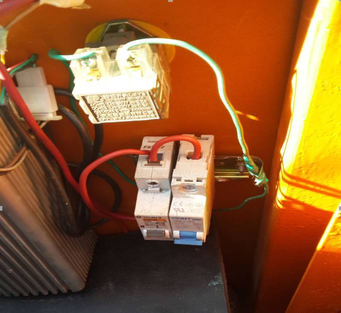 Two switches on orange color trailer: blue and white switch. And on the switch, there are two red electric wires.