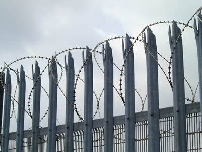 The top of security palisade fence with triple head corrugated W section combines with spiral razor wire and the section under the upper rail combines with 358 fence.