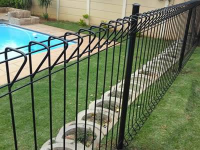 Roll top fence has rolled beam section at the top and bottom edge of each panel with no sharp or raw edges that is installed as swimming pool fencing.