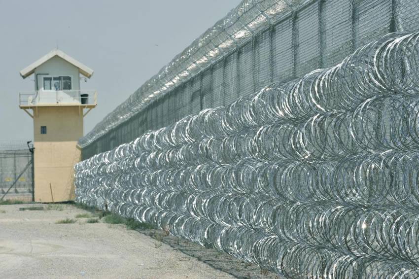 Prison wall is installed with five lines razor wire at the bottom and one line on the top.