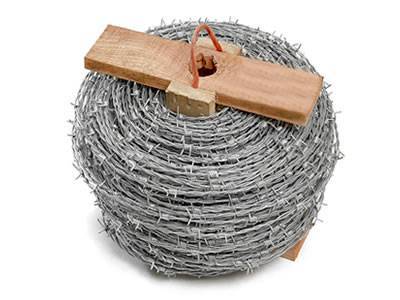 A roll of barbed wire with wooden roller and rope handle.