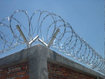 Concertina razor wires are installed at the top of residence wall.