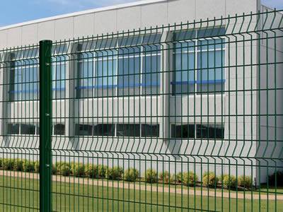 A green PVC coated welded wire 3D security fence is installed as a security wall for factory fencing.