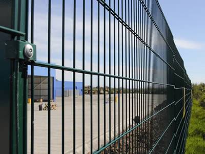 A dark green PVC coated welded double wire fence is installed at a factory.