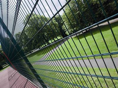 A dark green PVC coated welded double wire fence is installed at a park.