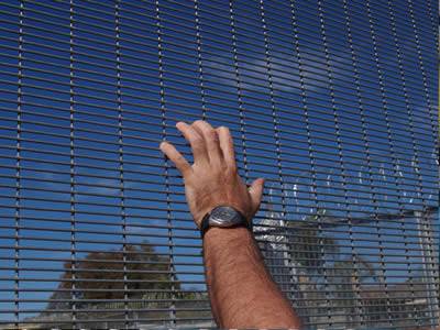 A galvanized prison security fencing of high height and small mesh size is finger-proof and accompanied by razor wire.