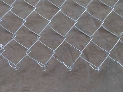 A corner of square hole shape chain link fence is on the floor.